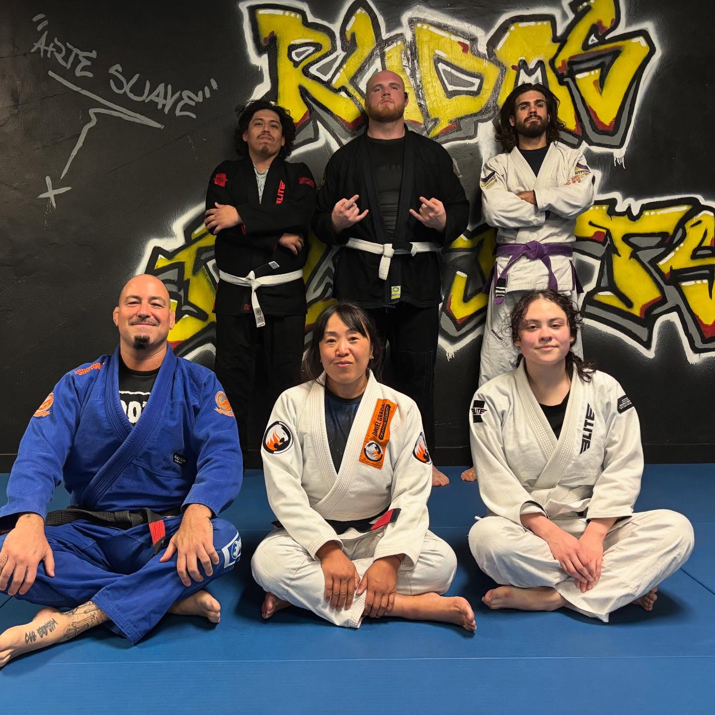 Monday Night Gi BJJ class at Rudos BJJ with Professor Karen Tran and Professor David Floridia beside the Arte Suave chalkboard